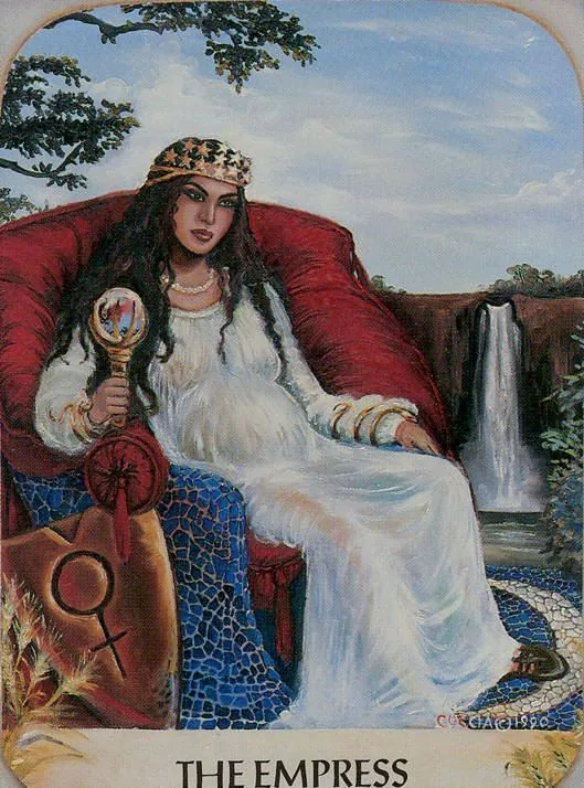 a tarot card with a woman sitting in a chair next to a waterfall and holding a magnifying glass