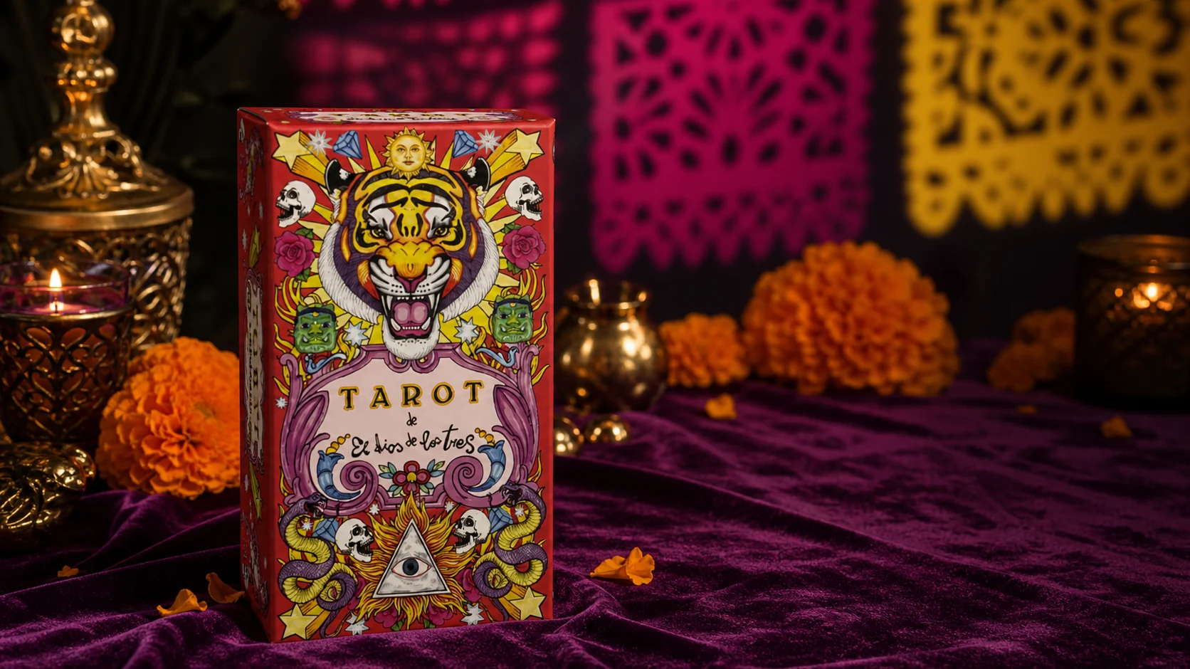 Tarot de El Dios de los Tres box on plum velvet with warm candlelight and marigold accents