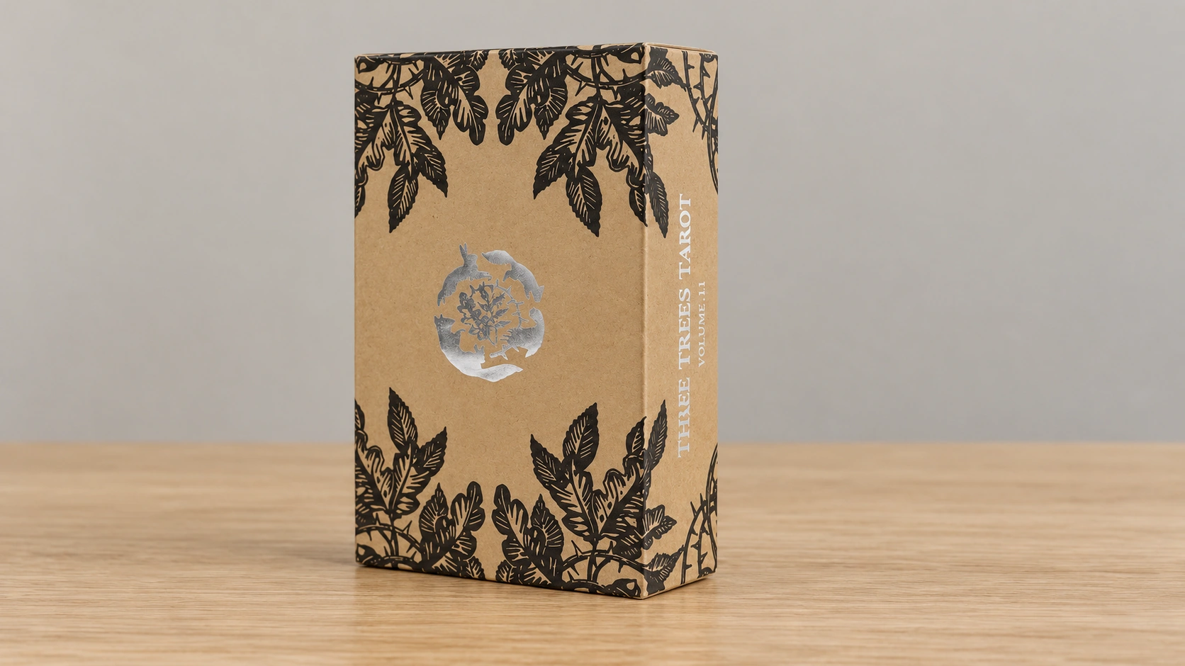 Oak, Ash & Thorn Tarot Deck by Stephanie Burrows and Adam Oehlers Generated illustrative scene of the classic Oak, Ash & Thorn Tarot Volume 1.1 kraft box on a basic wooden table, based on the supplied box reference