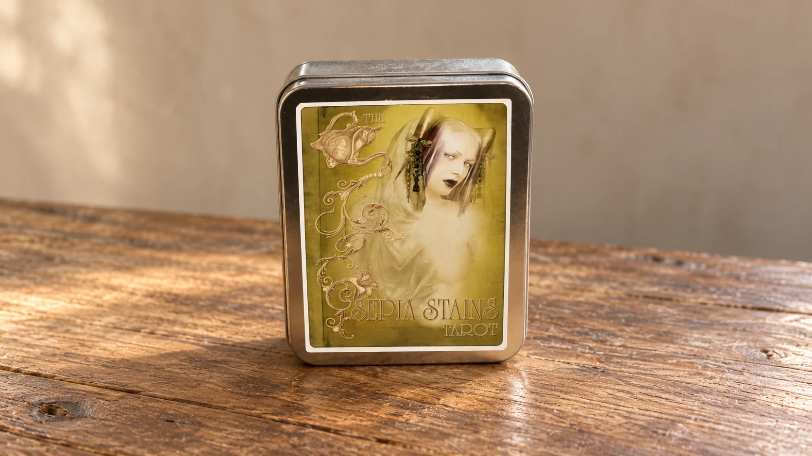 AI-generated editorial scene of the Sepia Stains Tarot Deck by Bethalynne Bajema: one closed second-edition silver tin on a bare wooden table against a plain neutral background