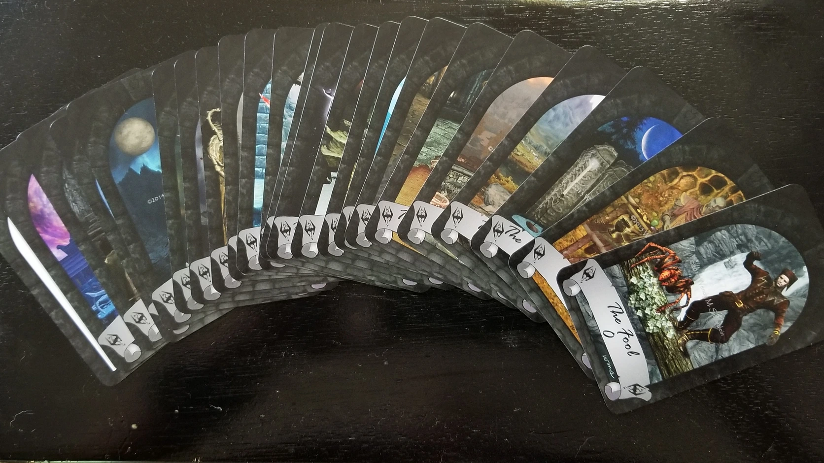 Creator-published photograph of Wendy M. Schardein&rsquo;s privately printed Skyrim Tarot cards fanned on a dark table