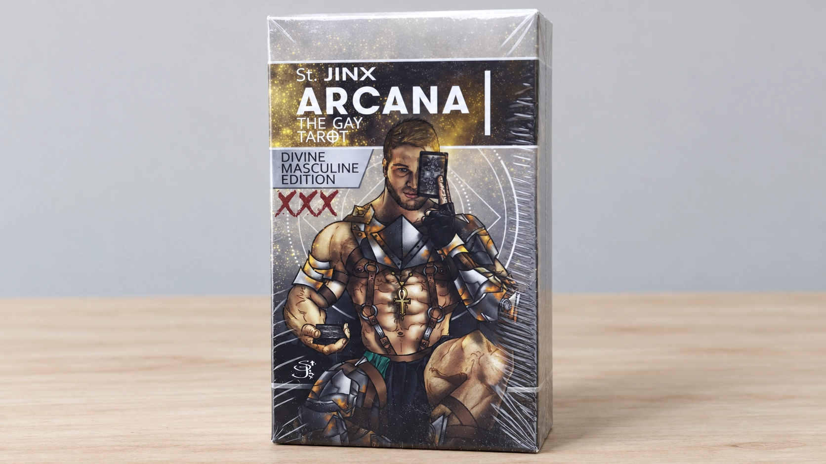 AI-generated scene of the supplied white St. Jinx Arcana Divine Masculine Edition XXX box alone on a bare table; packaging differs from the archived Gallery edition