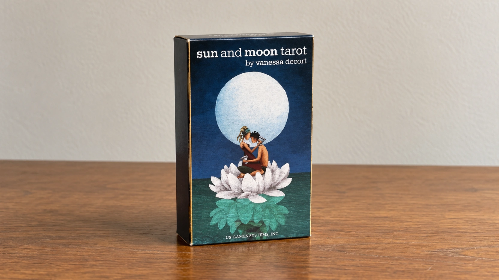 Generated scene showing the documented Sun and Moon Tarot box by Vanessa Decort alone on a plain wooden card table