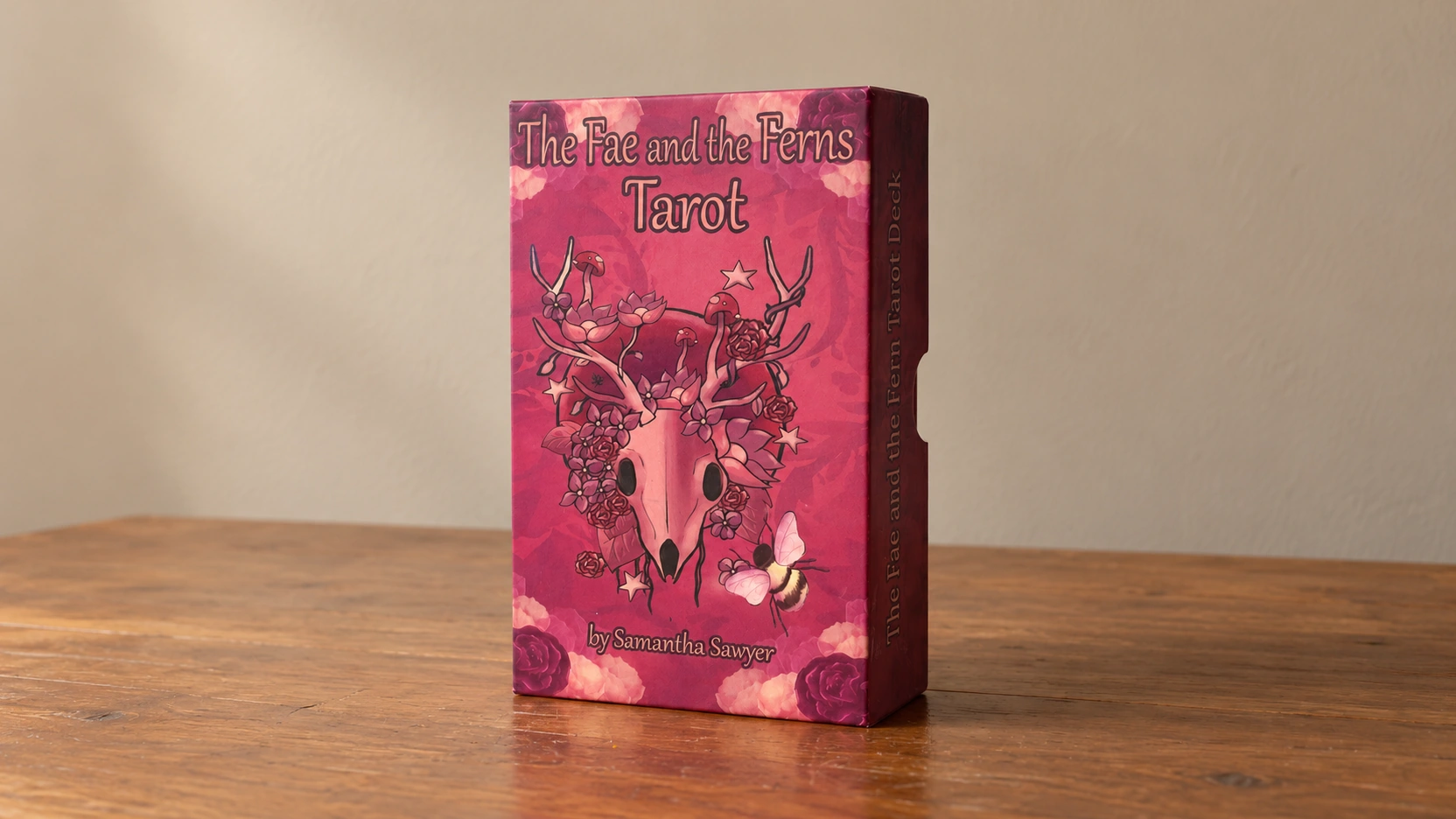 Generated scene of the documented pink Fae and the Ferns Tarot box by Samantha Sawyer alone on a plain wooden table